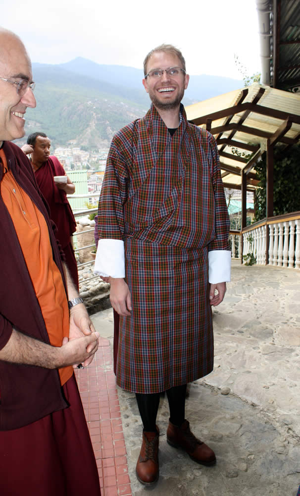 Alex Ryan surprises everyone by arriving dressed in the traditional Bhutanese men's outfit, the <em>gho</em>.