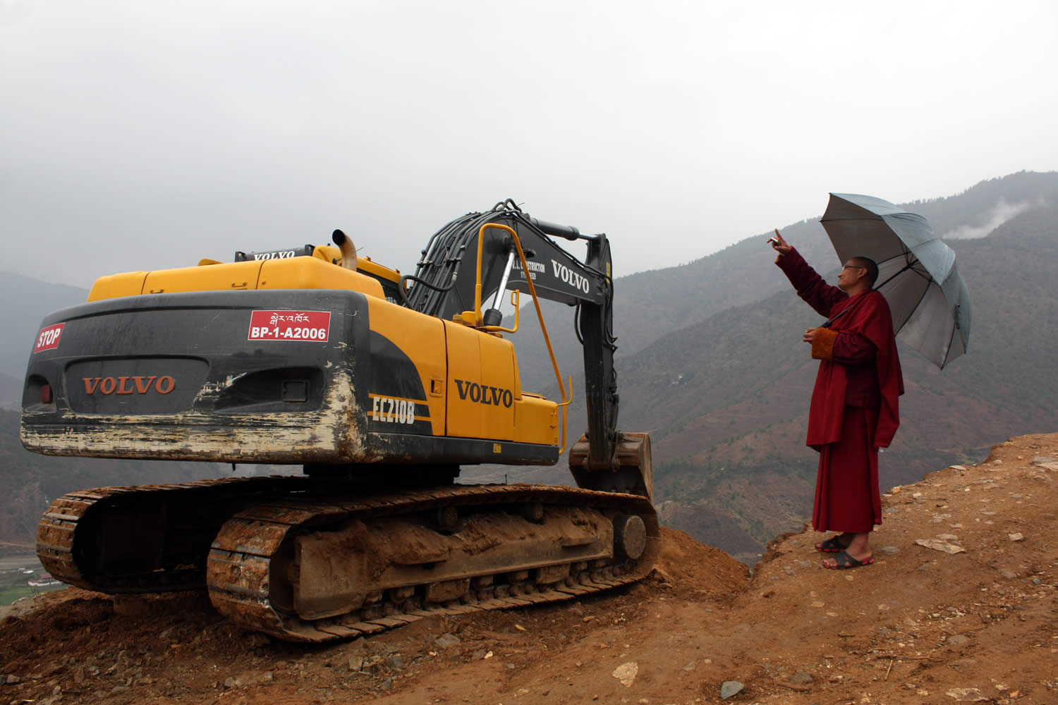 A monk from the Kila Gompa asks the machine operator to allow pilgrimage vechicles to pass.
