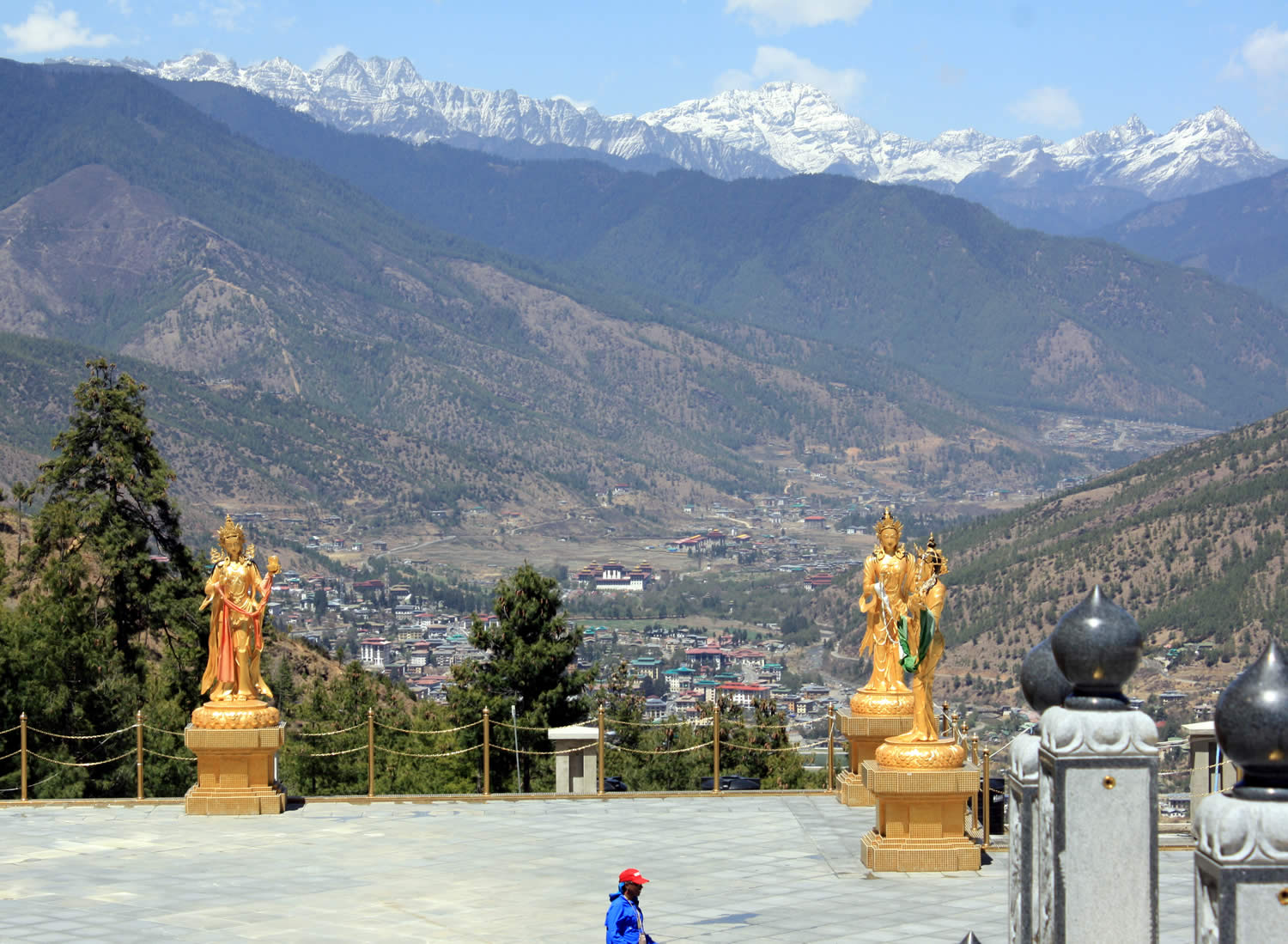 A breath-taking view of the Himalayas rising above the city of Thimphu with several of the offering goddesses in the foreground  as seen from Kunsel Phodrang.